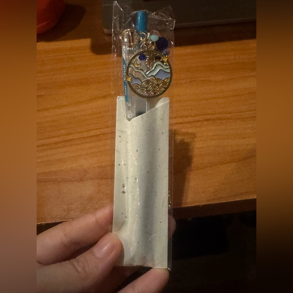 Gold and Blue Wave key charm with a light blue pen.